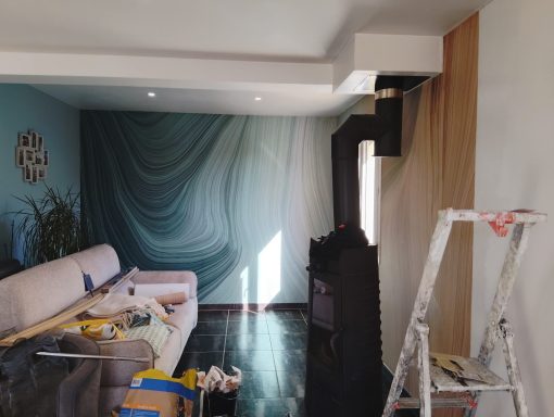 Salon en cours de rénovation avec des murs colorés, des outils et une échelle.