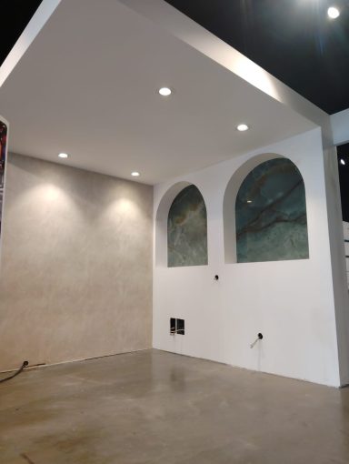 Intérieur d'une pièce avec des murs clairs et des fenêtres en arc peintes.